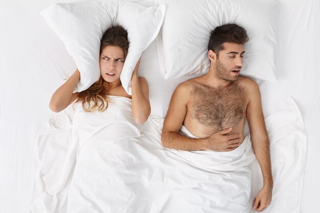 Woman and man sitting in bed top view