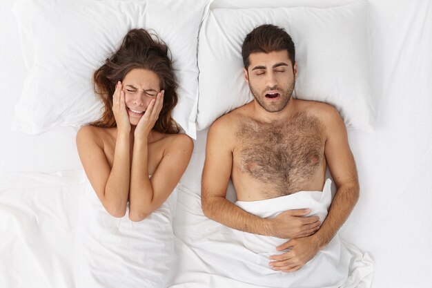 Woman and man sitting in bed top view