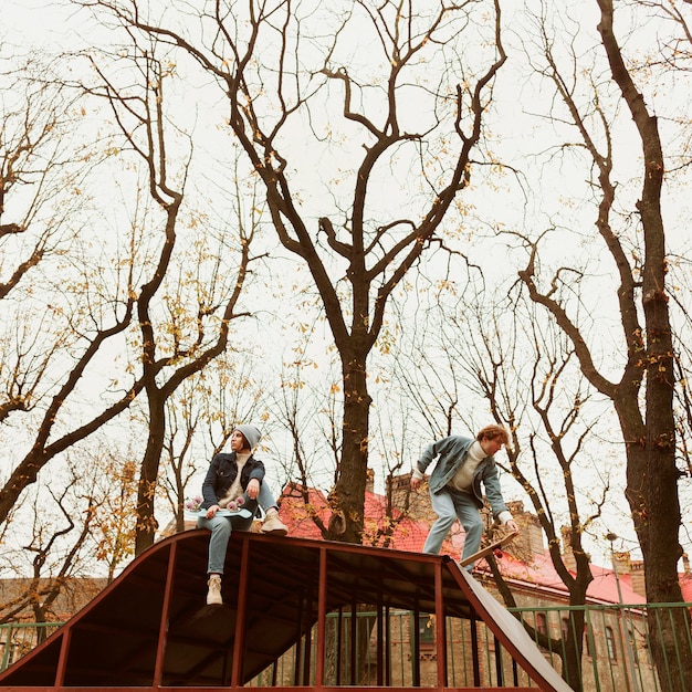 Woman and man skateboarding outdoors