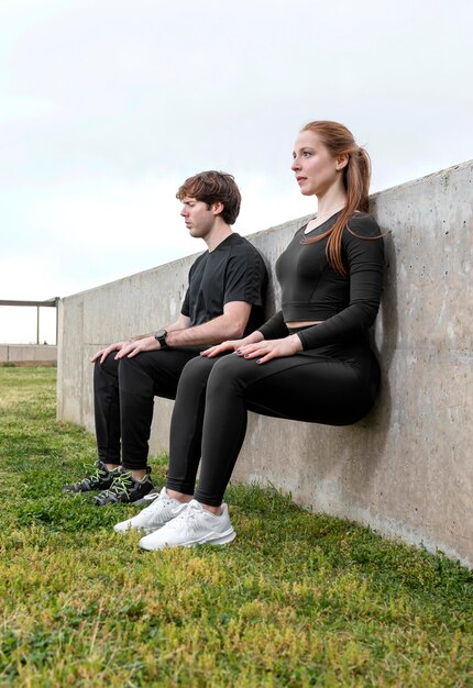 Woman and man in sportswear exercising outdoors