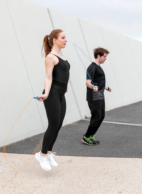 Woman and man in sportswear exercising outdoors