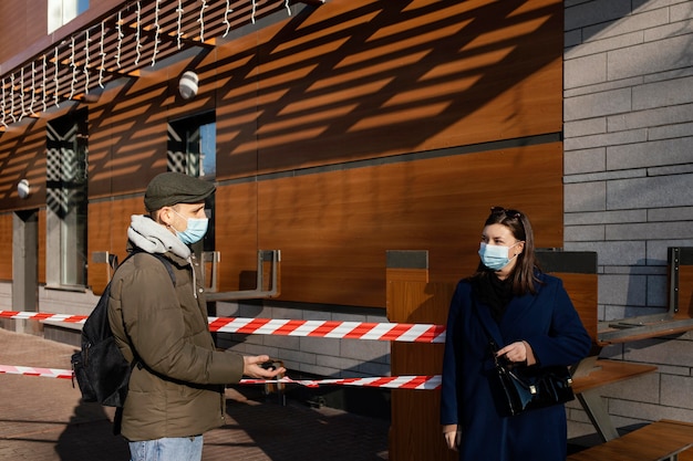 Woman and man on street wearing mask
