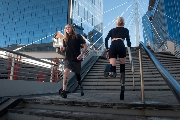 Woman and man with leg disability running in the city