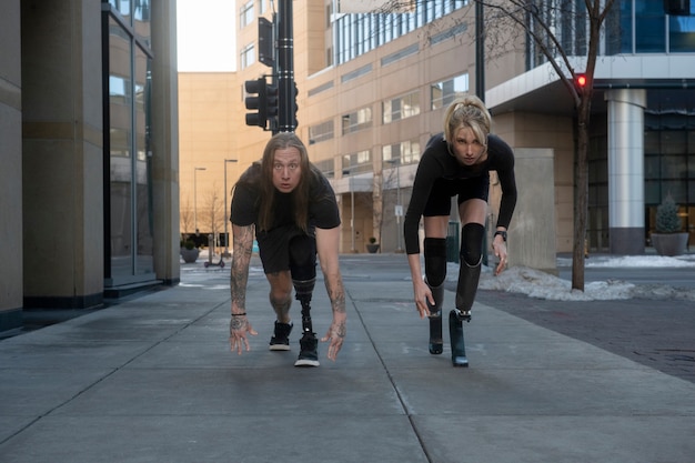 Woman and man with leg disability running in the city