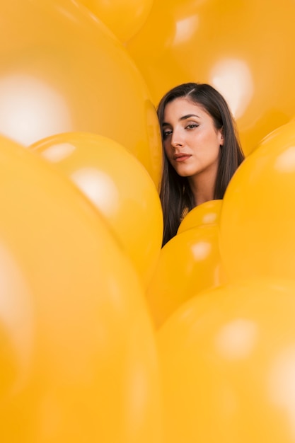 Женщина между много желтых воздушных шаров