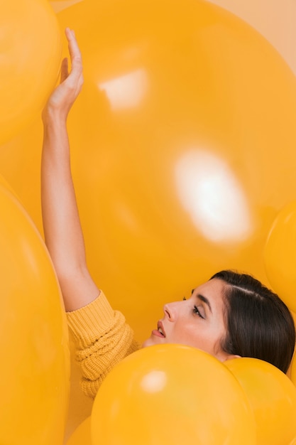 Woman between many yellow balloons