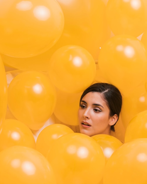 Foto gratuita donna tra molti palloncini gialli