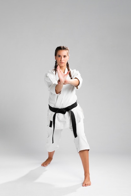 Woman in martial arts uniform exercising karate