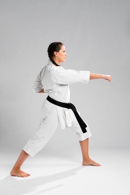 Woman in martial arts uniform exercising karate