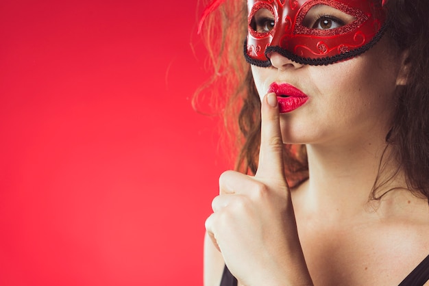 Woman in mask gesturing silence