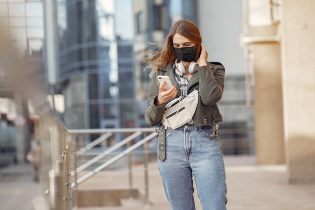 Woman in a mask stands on the street