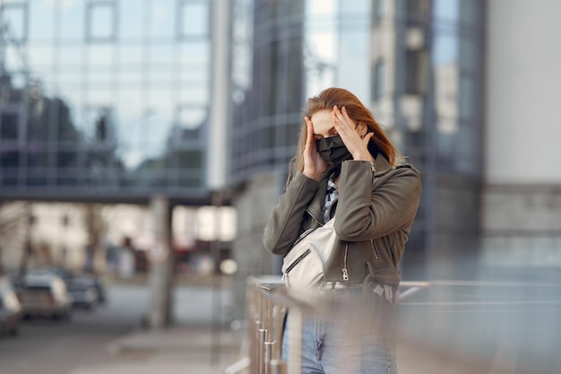 仮面の女が通りに立っています。