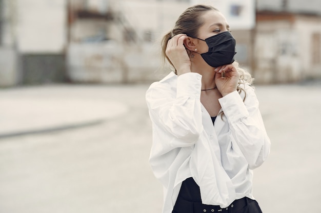 Woman in a mask stands on the street