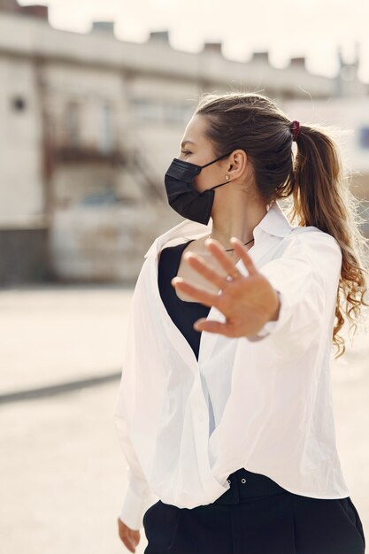 Woman in a mask stands on the street