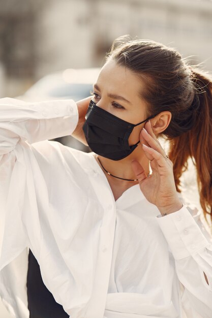 Woman in a mask stands on the street