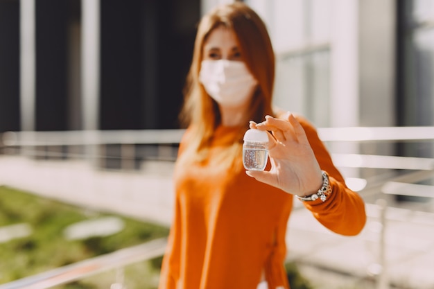 Woman in a mask stands on the street