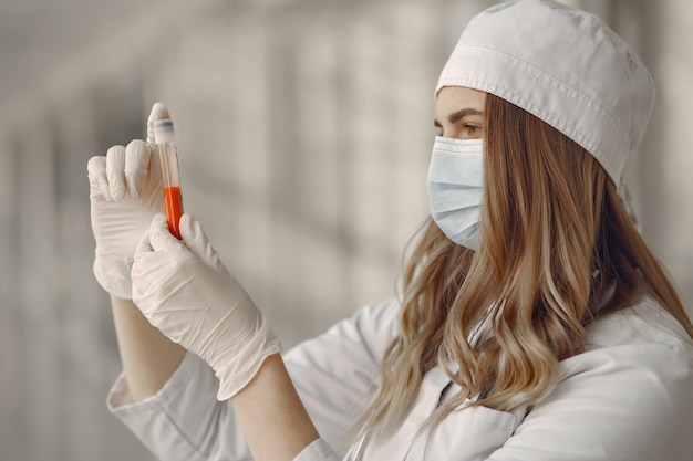 Foto gratuita donna in una maschera e uniforme in possesso di un tubo nelle sue mani