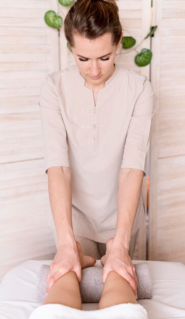 Woman massaging client's legs