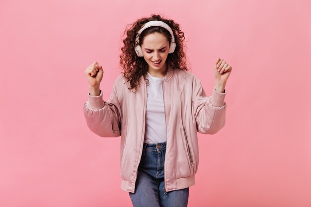 Free photo woman in massive headphones listens to music and dances