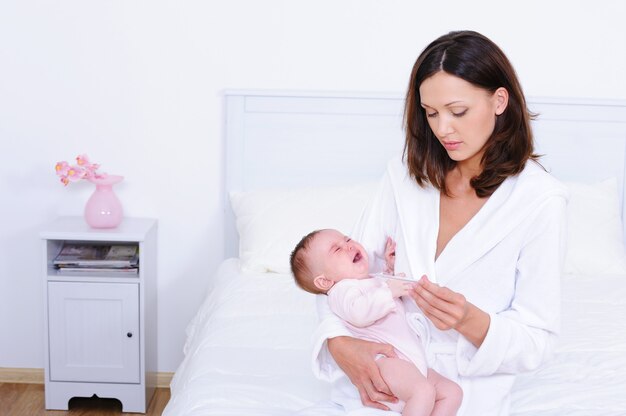 無料写真 彼女の息子に温度を測定する女性