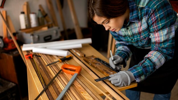 Woman measuring wood planks