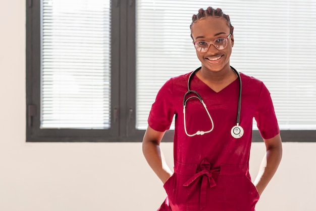 Woman medic wearing stethoscope and red uniform