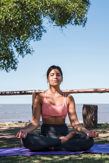 Free photo woman meditating at beach