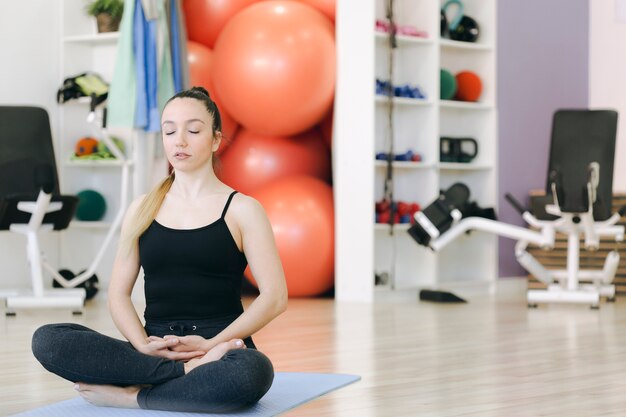 Foto gratuita donna che medita in palestra