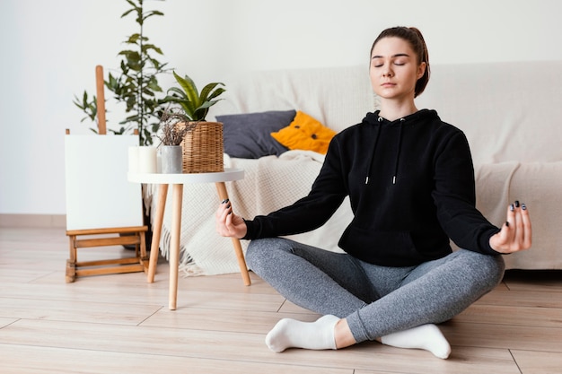 Foto gratuita donna meditando al coperto