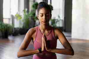 Free photo woman meditating indoors front view