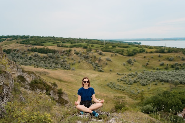 Женщина медитации расслабляющий в одиночку. Путешествие на здоровый образ жизни с красивым пейзажем
