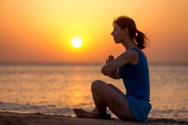 Женщина медитации на берегу моря