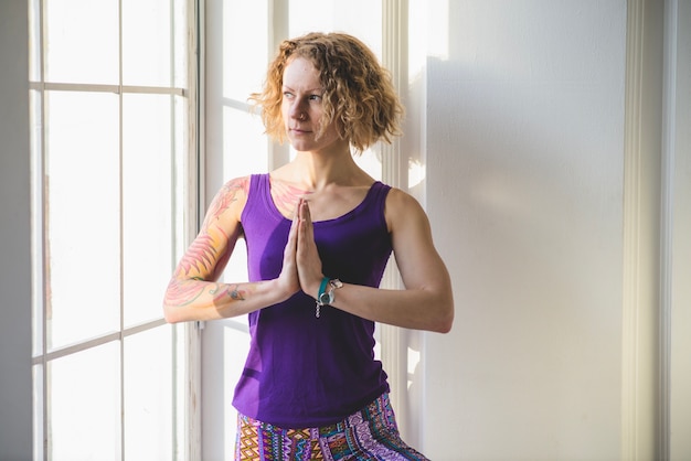 Free photo woman meditating at window