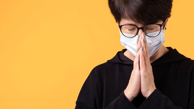 Woman meditating with a face mask on with copy space