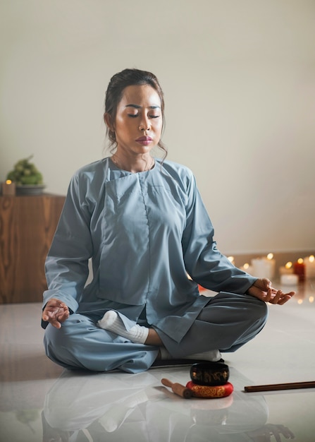 Женщина медитирует с поющей чашей и ладаном