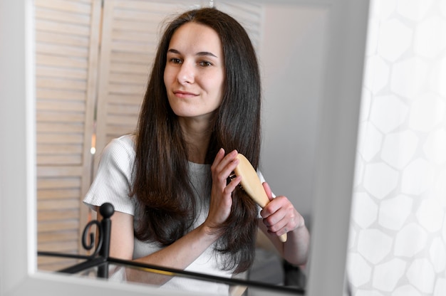 woman in mirror brushing hair
