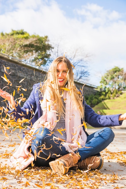 Free photo woman model sitting on windy autumn ground