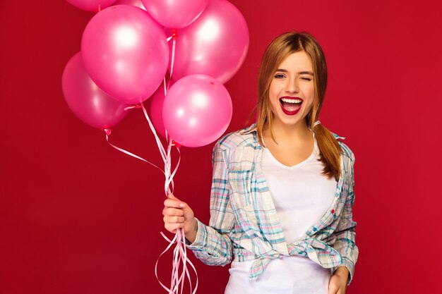 Модель женщины с розовыми воздушными шарами. подмигивать