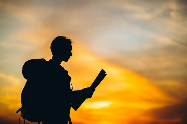 Woman in mountain with travel bag looking at map