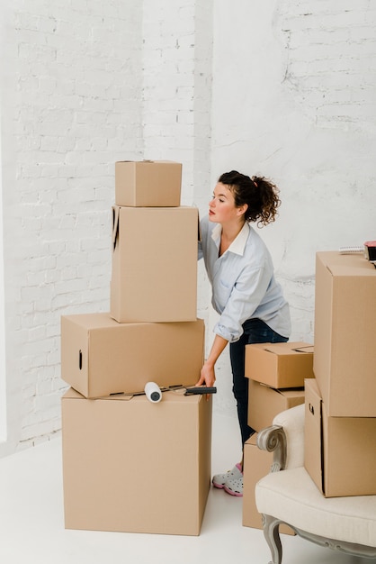 Woman moving stack of boxes