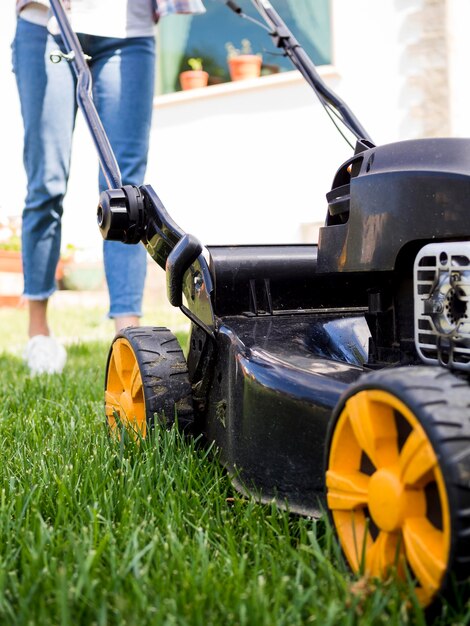 Woman mowing the yard close-up