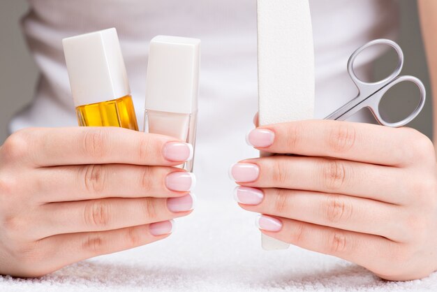 Woman in a nail salon receiving manicure by a beautician. Beauty treatment concept.