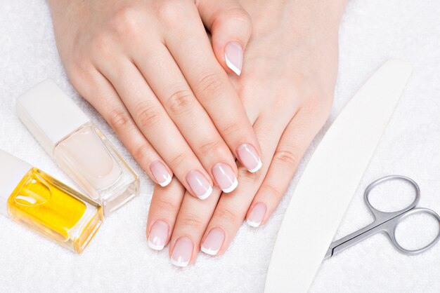 Woman in a nail salon receiving manicure by a beautician. Beauty treatment concept.