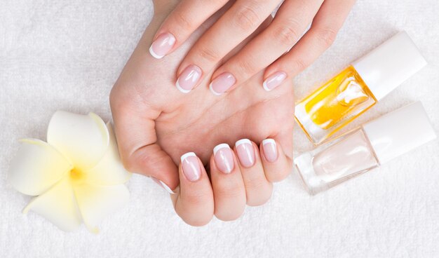 Woman in a nail salon receiving manicure by a beautician. Beauty treatment concept.