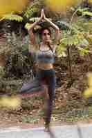 Free photo woman in nature doing yoga