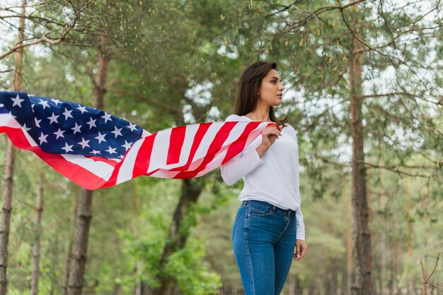 woman in nature holding american flag