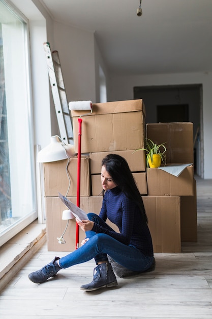 Woman near boxes and paint roller