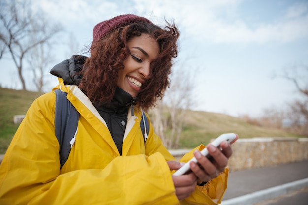 スマートフォンを使用して道路の近くの女性