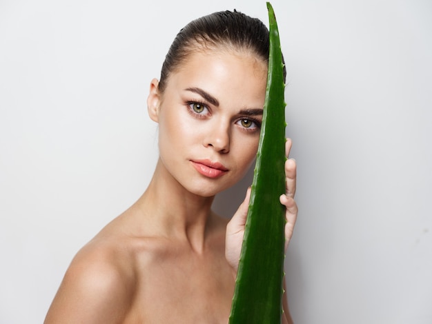 합성 계획 깨끗한 피부 미용 자연 모습에 녹색 알로에 잎 옆에 있는 여자