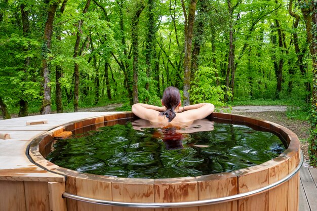 Woman in nordic bath in front of a forest